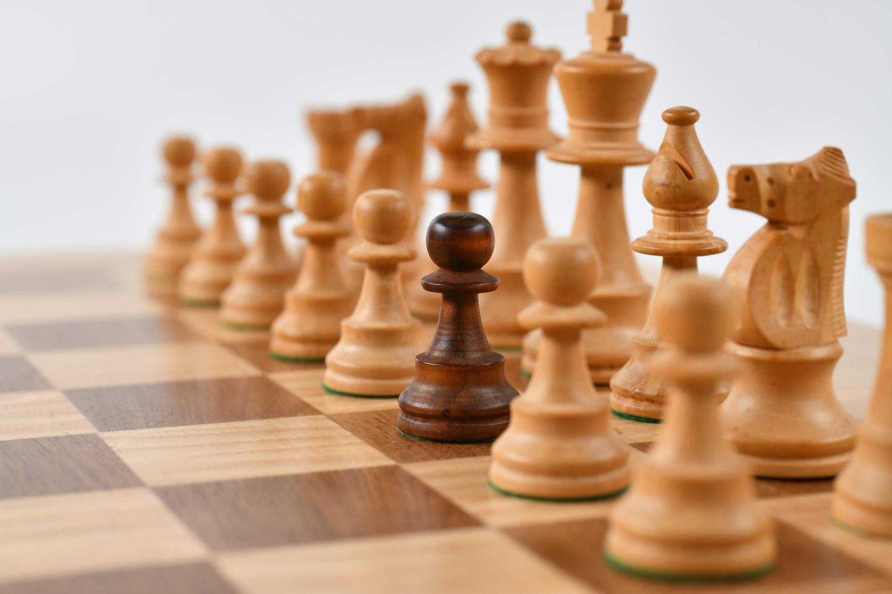 Wooden chess pieces arranged on a board